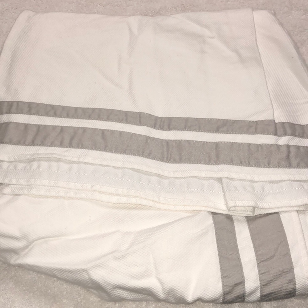 White crib skirt with gray stripes.